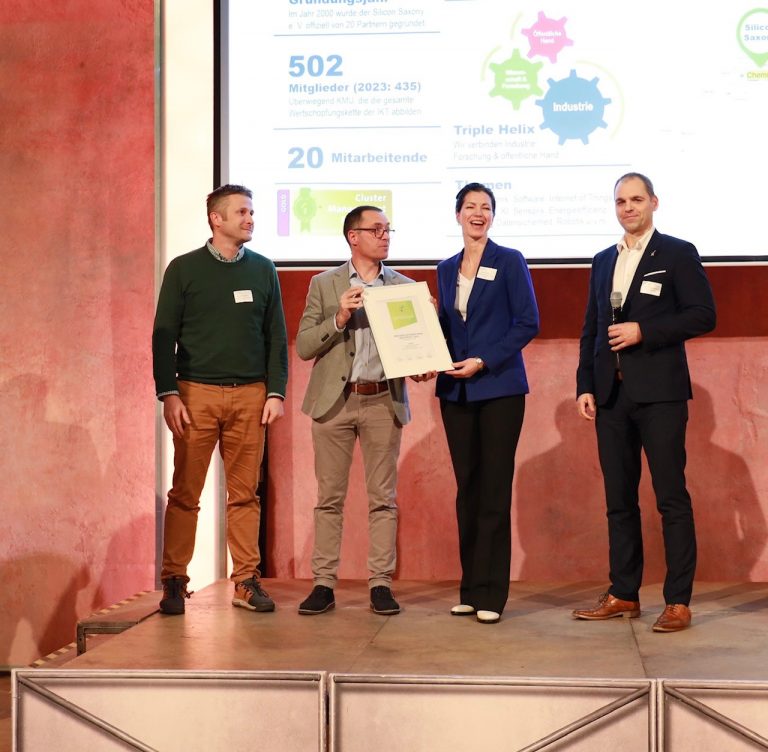 Übergabe der Urkunde auf der Bühne.