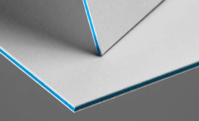 Mehrschichtkarton mit cyanfarbener Kernlage, wie er für den Druck von Visitenkarten für den Bereich ›Transfer‹ eingesetzt wird.
