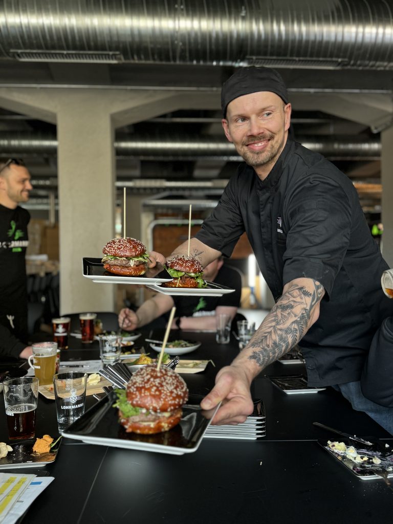 Kuechenchef Sasch Denninger mit einem Burger